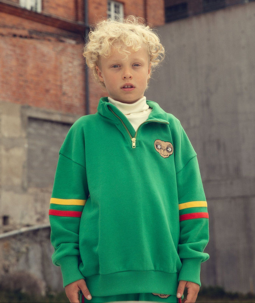 Mini Rodini E. T. limited release green sweatshirt | half-zip front | standup collar | red & yellow stripes on sleeves | banded at wrist & waist |   kids size modeled