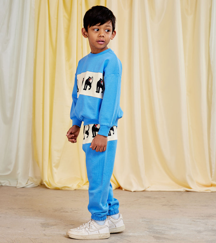 Mini Rodini Panther sweatpants | white hip bad with panther repeated print | beautiufl aqua bottom of pant  elasticized waist and ankles | organic cotton |  kids size modeled