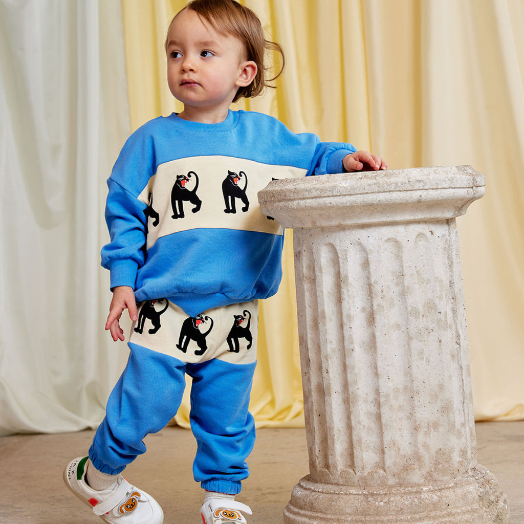 Mini Rodini Panther sweatpants | white hip bad with panther repeated print | beautiufl aqua bottom of pant  elasticized waist and ankles | organic cotton |  Modeled
