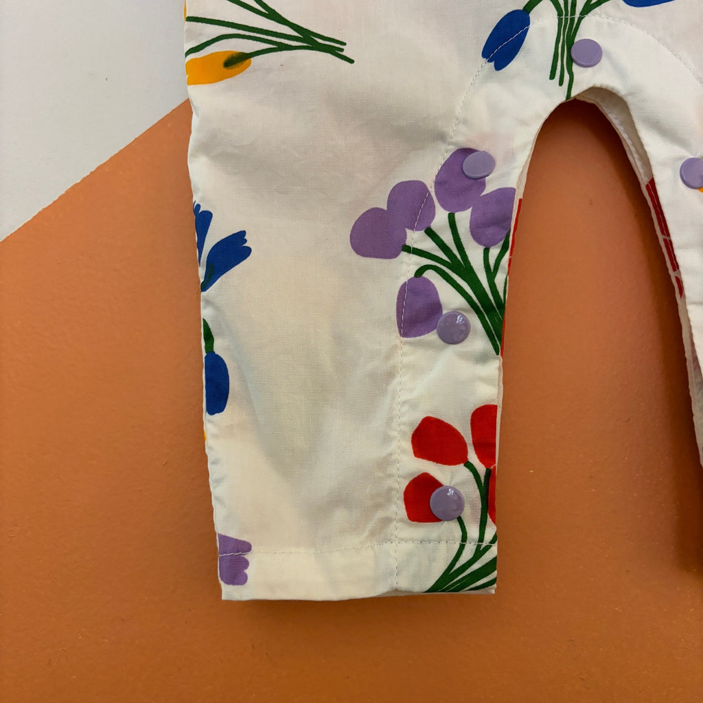 Lightweight Infant Cotton Jumper with Summer Flowers Print | White w/red/yellow/purple/blue floral | Patch Pocket on Front | Button close at shoulders | Snaps at legs for easy changing - leg closeup
