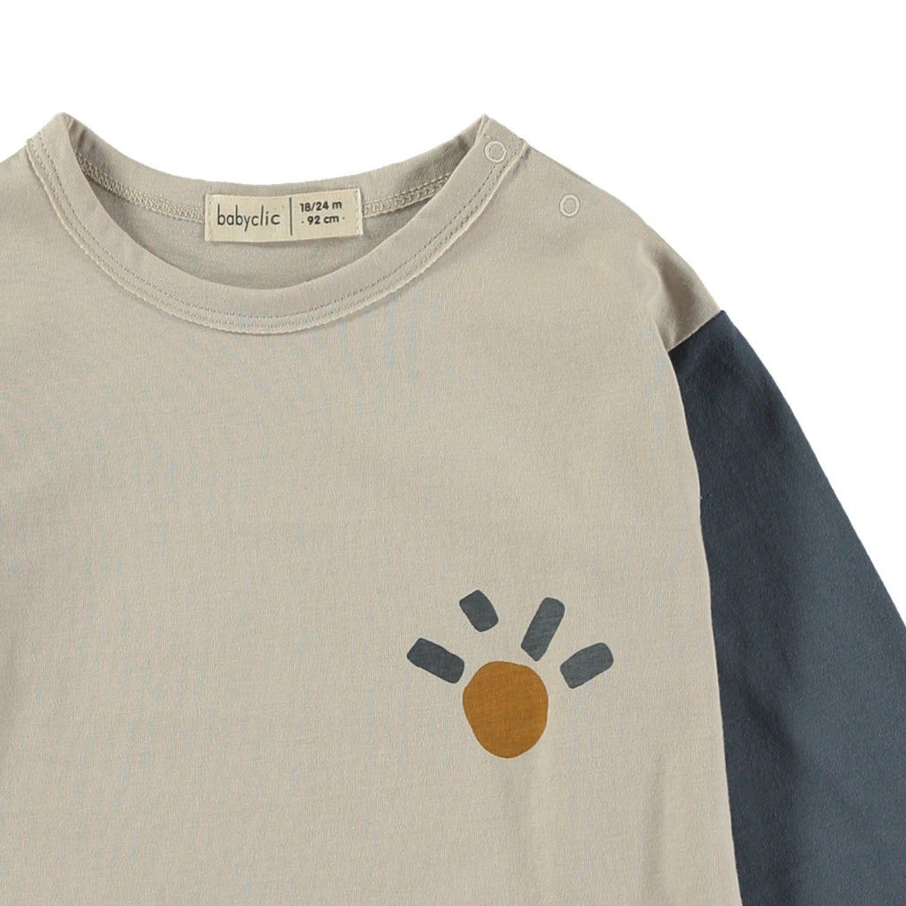Tricolor Organic Cotton Long Sleeve Tee by quality brand Babyclic | Blue and Mustard Sleeves on this Off-White Shirt | Drop Shoulder for Comfort | single Sun graphic on front - closeup