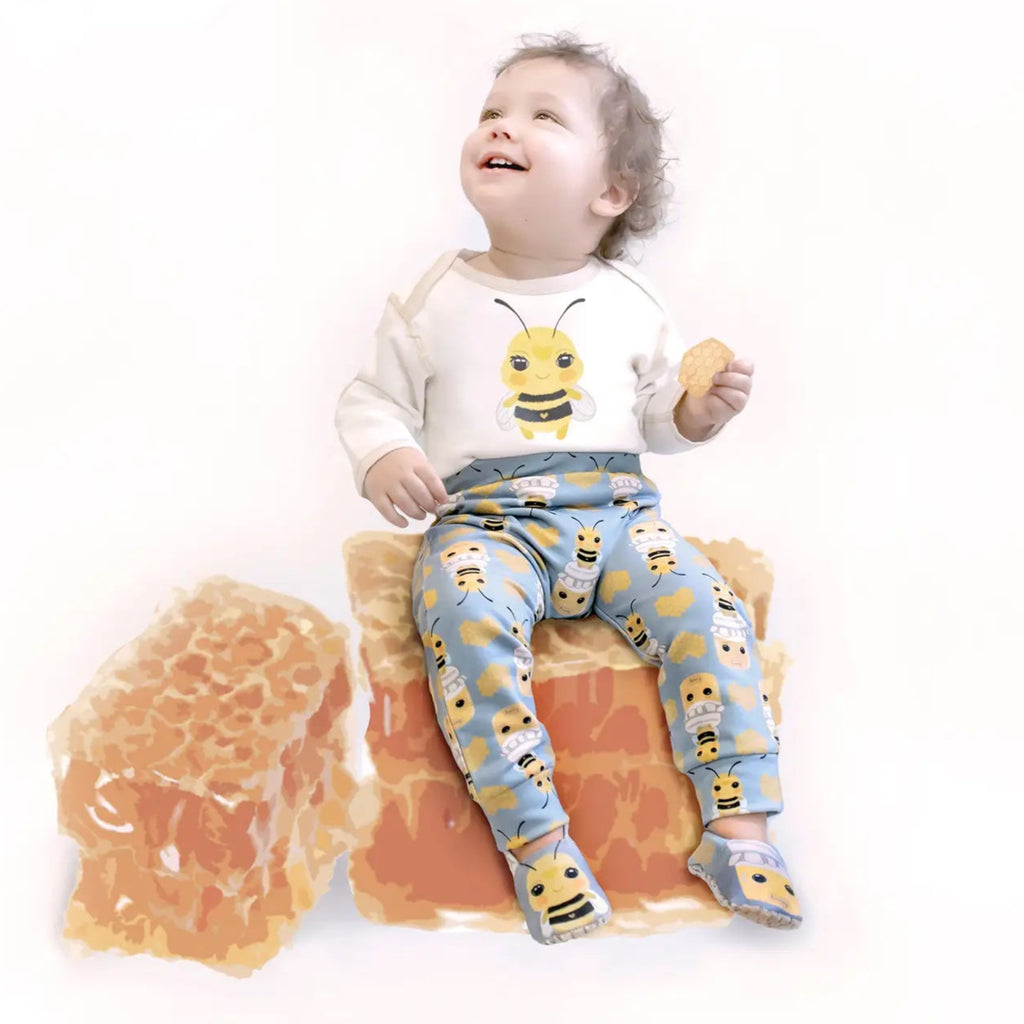 cotton long sleeve white onesie | cute bee graphic on front, | stinger graphic on back | beige trim | model