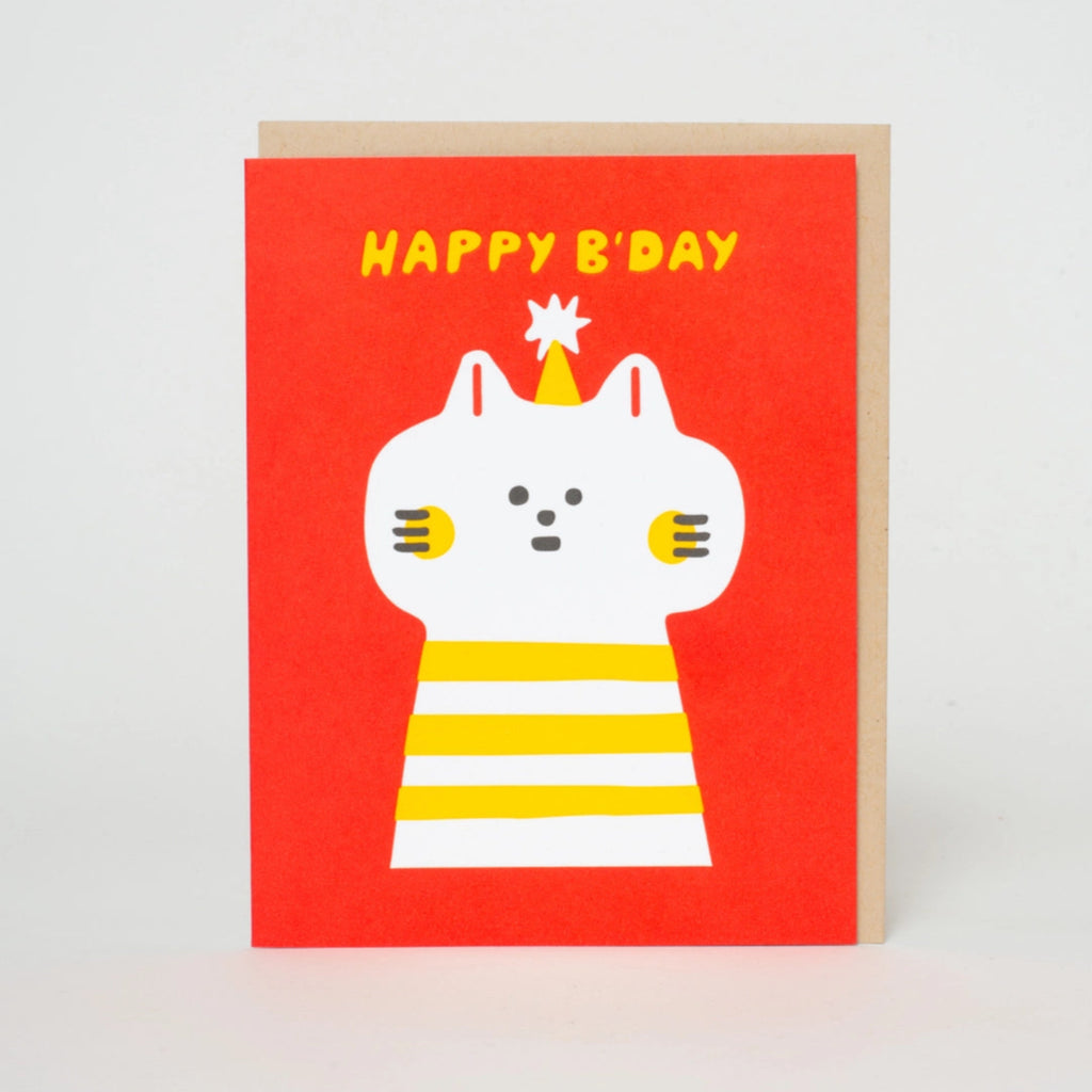 A birthday card with an illustration of a cat in a striped shirt and a birthday hat  with the text 'Happy B'day' on an orange background. A envelope is partially visible behind the card.  Blank inside