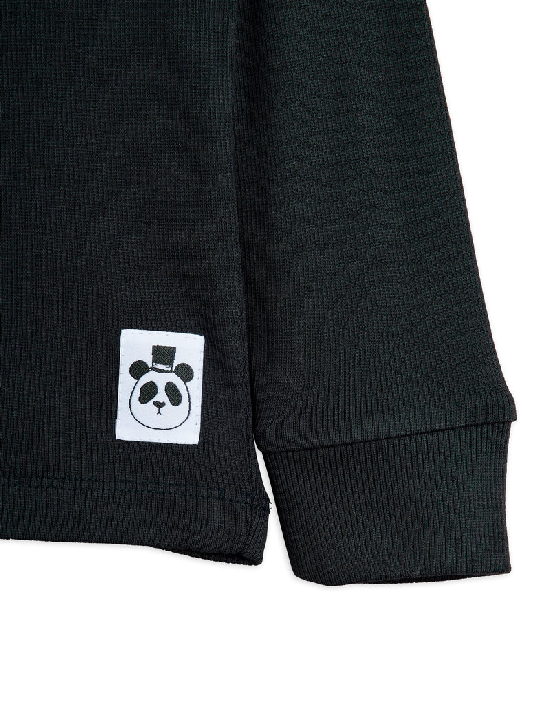 Black Tee by Mini Rodini made with very soft modal fabric, long sleeves ribbed at wrist, snap buttons at shoulder, wrist closeup