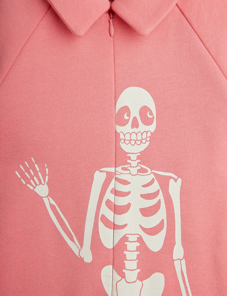 All cotton cotton pink jumpsuit | zip-up front | skeleton graphic on front | elasticized waist in back with 2 pockets | closeup of front