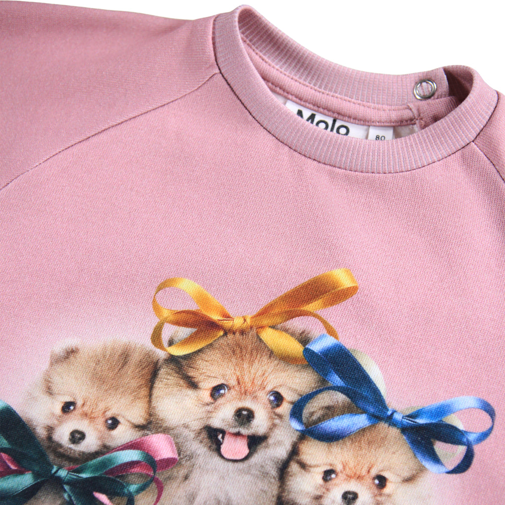 Pink organic cotton sweatshirt | digital print puppies and bows | ribbing at neck/wrist/waist | snap close a back of neck | front closeup