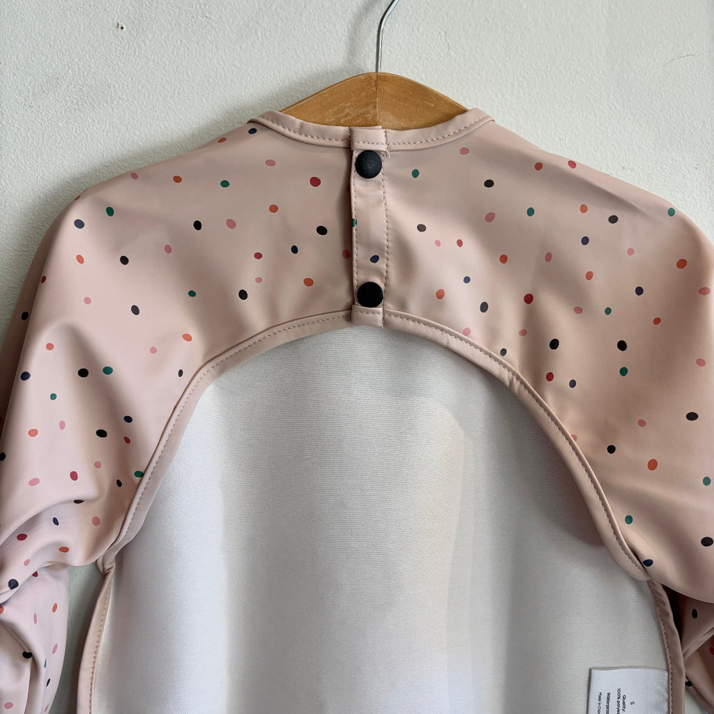 Pink bib with colorful polka dots | long sleeves | waterproof | pocket for catching spills | back snap close